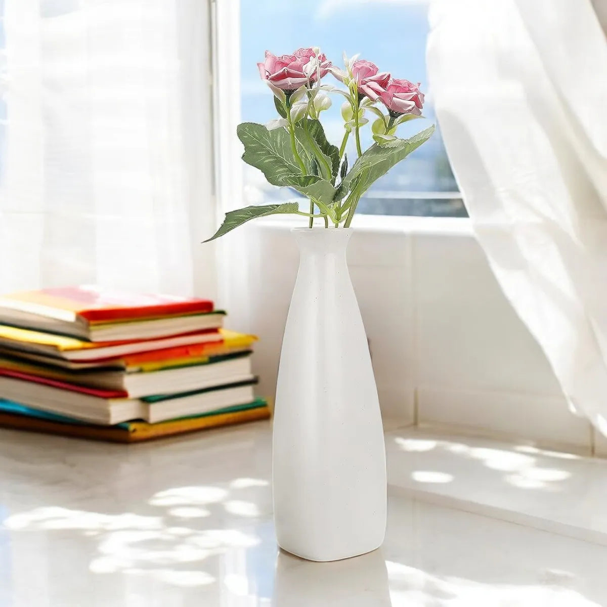 White ceramic triangular bottle vase with pink flowers, modern minimalist accent for home decor.
