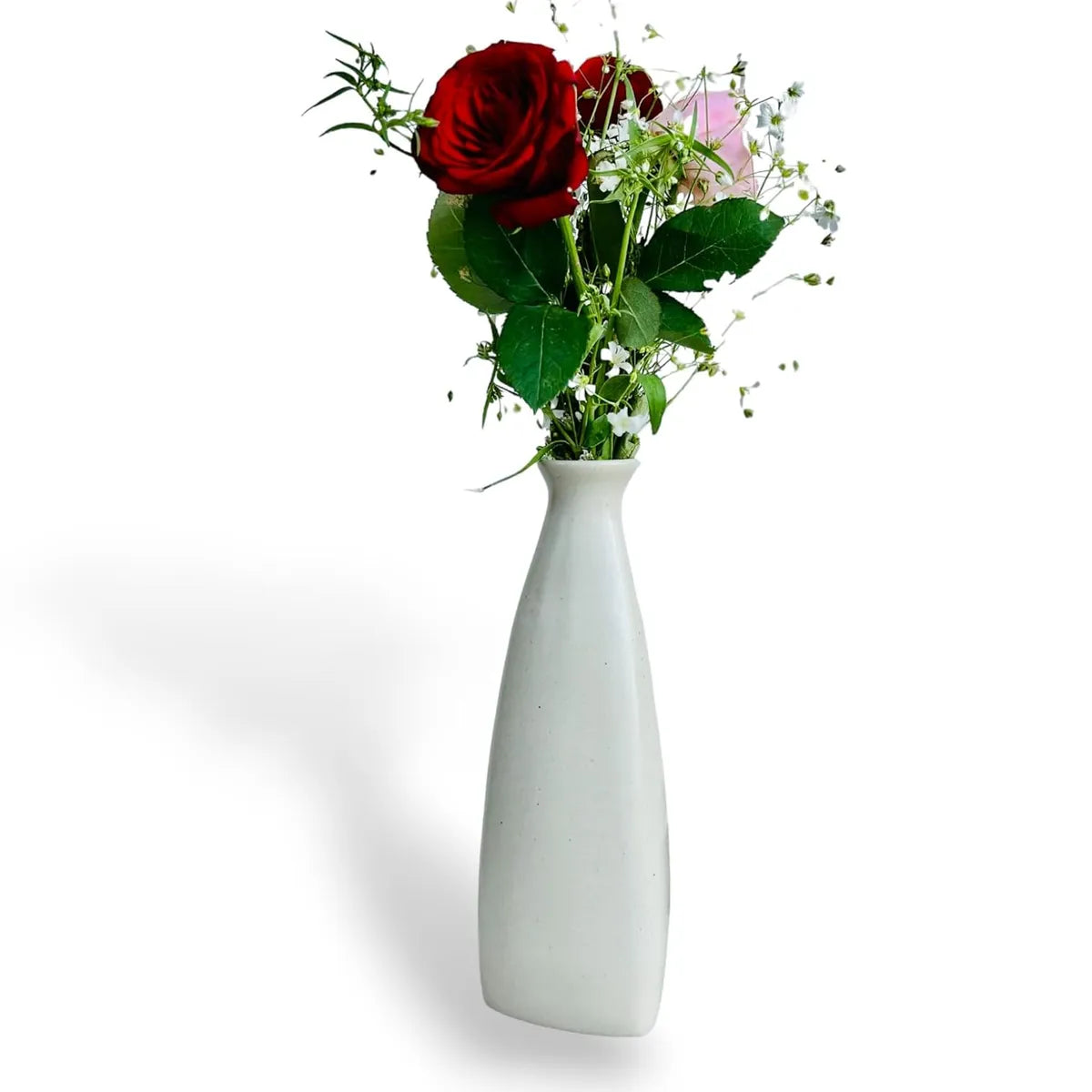 Aesthetic white ceramic triangular bottle vase with fresh flowers for modern home decor.